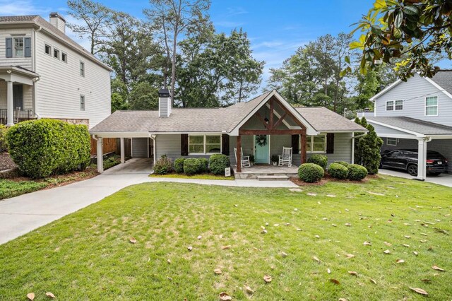 view of front facade featuring a carport, a front yard, a chimney, concrete driveway, and covered porch