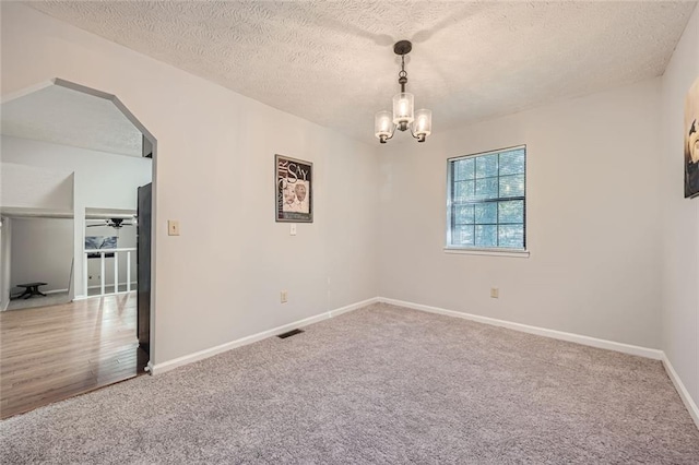 6118 Dana Ct, Lithonia, GA 30058 - empty room featuring carpet flooring, a chandelier, arched walkways, and a textured ceiling