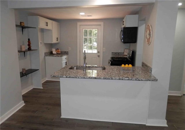 2040 Penelope St NW, Atlanta, GA 30314 - kitchen with range with gas cooktop, a sink, light stone counters, white cabinets, and a peninsula