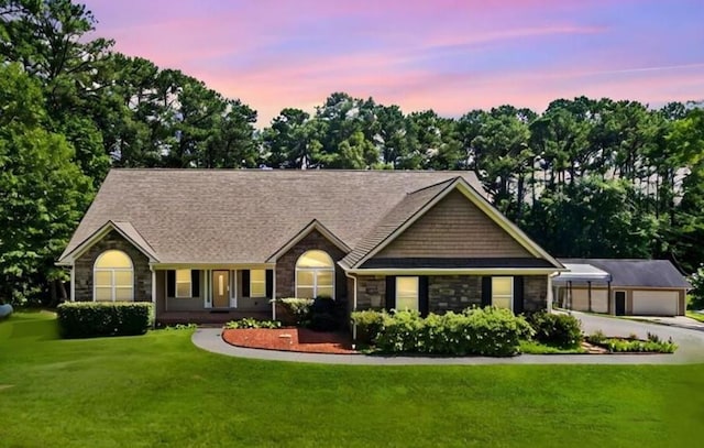 single story home featuring a front lawn, an outbuilding, and stone siding