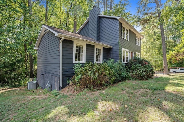 view of side of property featuring central AC and a yard