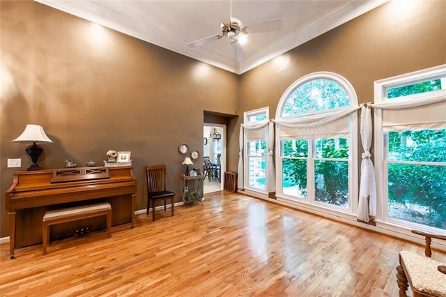 hallway with light wood-type flooring, ornamental molding, and an inviting chandelier