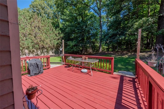 wooden terrace with a lawn and grilling area