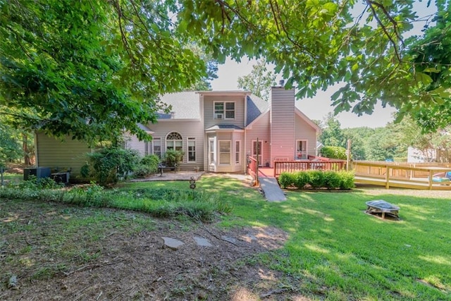 rear view of house featuring a deck and a yard