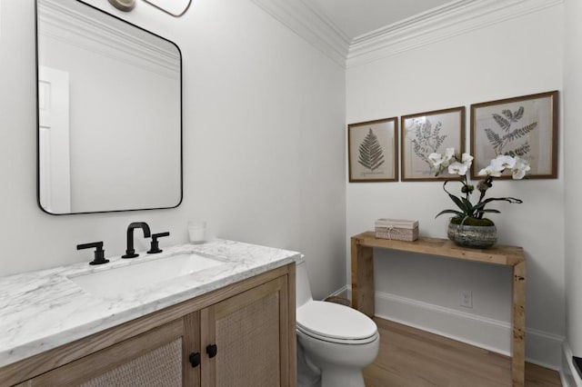 bathroom featuring vanity, crown molding, toilet, and hardwood / wood-style flooring