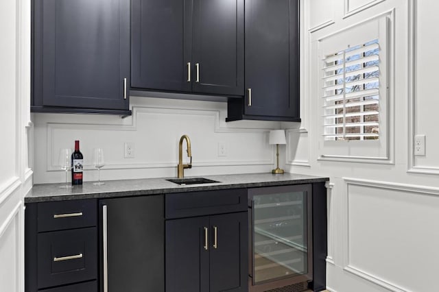 kitchen featuring sink, beverage cooler, and stainless steel refrigerator