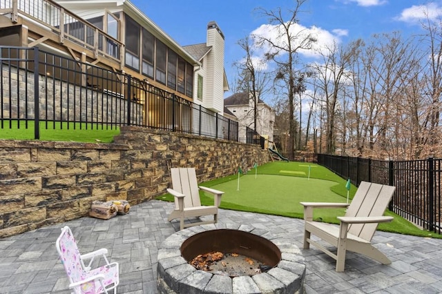 view of patio with a sunroom and a fire pit