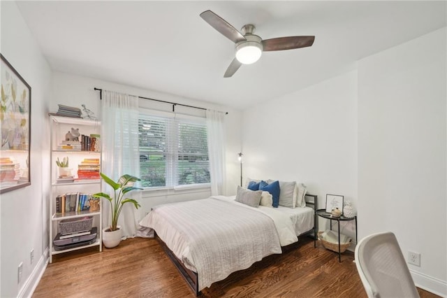 bedroom with baseboards, ceiling fan, and wood finished floors