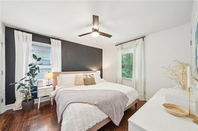 bedroom featuring baseboards, dark wood finished floors, and ceiling fan
