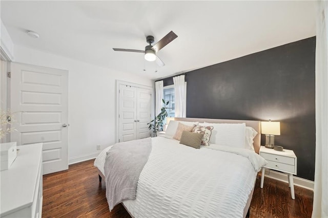 bedroom featuring a ceiling fan, baseboards, wood finished floors, and a closet