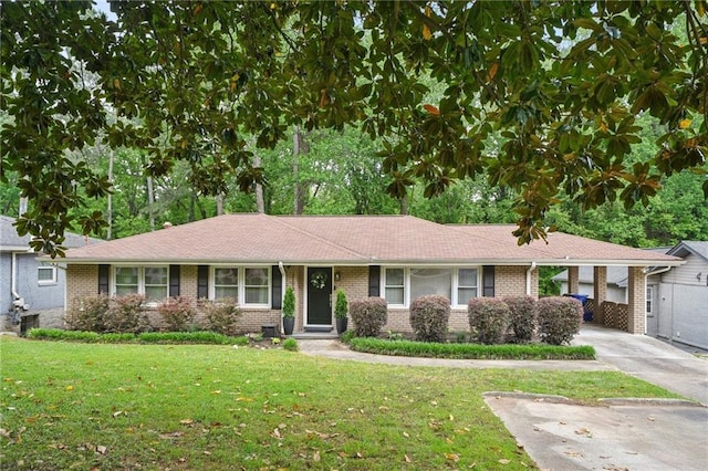 single story home featuring concrete driveway, brick siding, a front yard, and a carport
