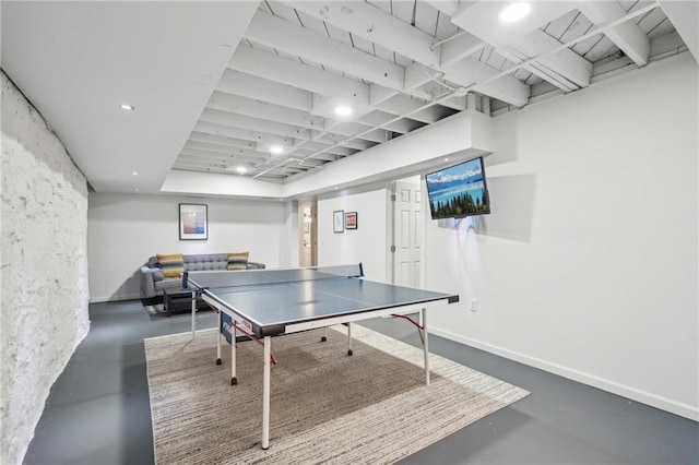 recreation room featuring baseboards and finished concrete floors