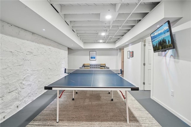 recreation room featuring finished concrete floors and baseboards