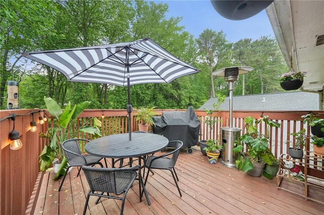 wooden deck featuring outdoor dining space and area for grilling