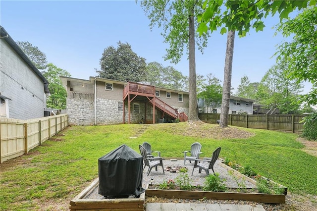 rear view of house featuring a fenced backyard, stairs, a yard, and a deck