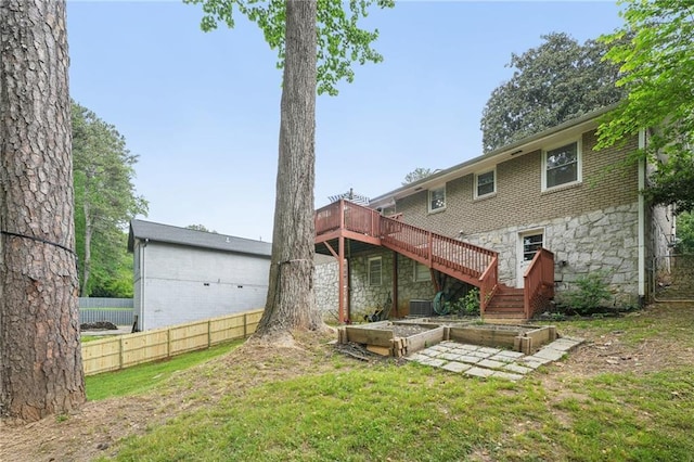 back of property with stairway, a deck, fence, and stone siding