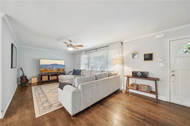 living area with crown molding, a ceiling fan, baseboards, and wood finished floors