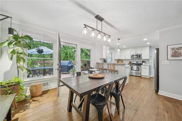 dining space featuring baseboards, ornamental molding, and recessed lighting