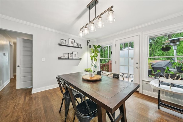 dining area with baseboards, ornamental molding, and wood finished floors