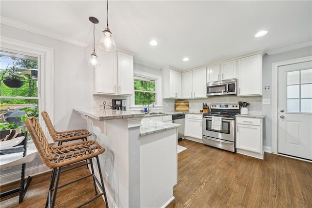 kitchen featuring stainless steel appliances, white cabinetry, tasteful backsplash, and a peninsula