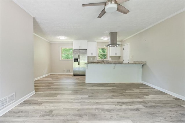 2172 SE Wakita Dr SE, Marietta, GA 30060 - kitchen featuring stainless steel fridge, island exhaust hood, white cabinetry, a peninsula, and a textured ceiling