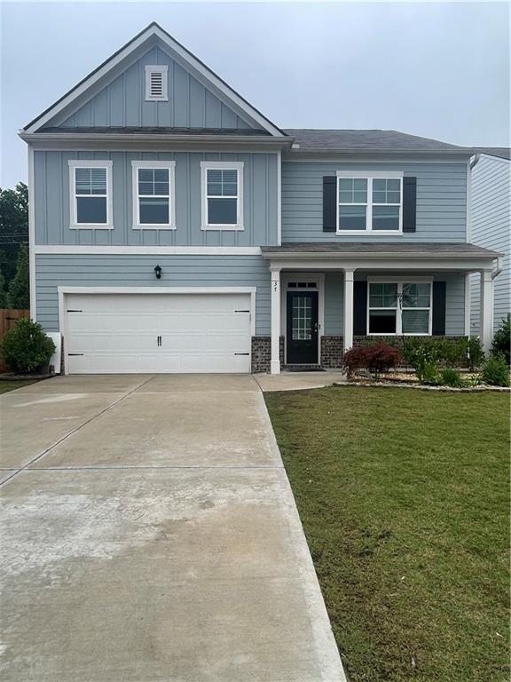 37 Creekbed Ct, Dawsonville, GA 30534 - craftsman house with a garage, board and batten siding, driveway, a front lawn, and a porch