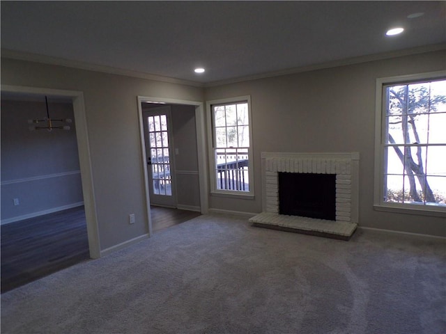 unfurnished living room featuring a wealth of natural light, a fireplace, and crown molding