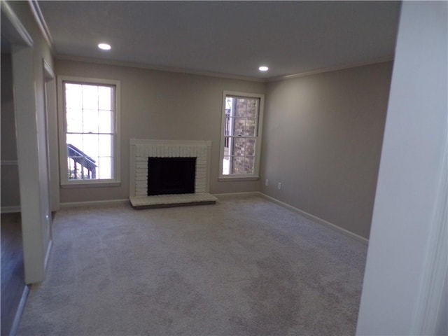 unfurnished living room with baseboards, a brick fireplace, carpet flooring, and crown molding