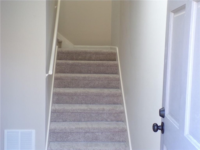 stairway with baseboards and visible vents