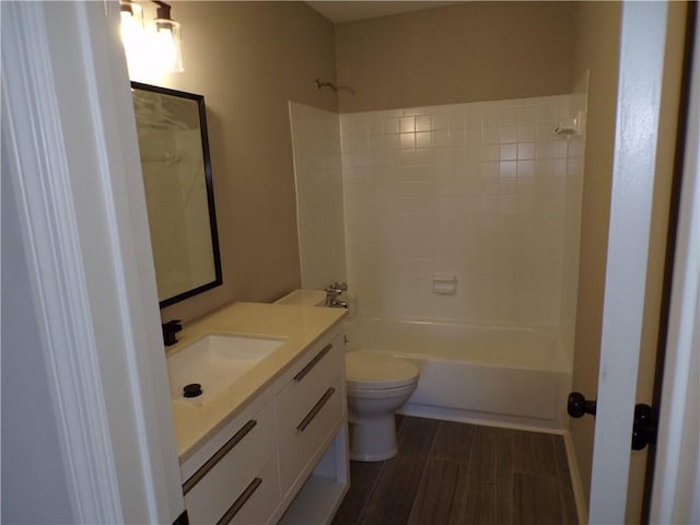 bathroom with toilet, bathing tub / shower combination, wood finished floors, and vanity