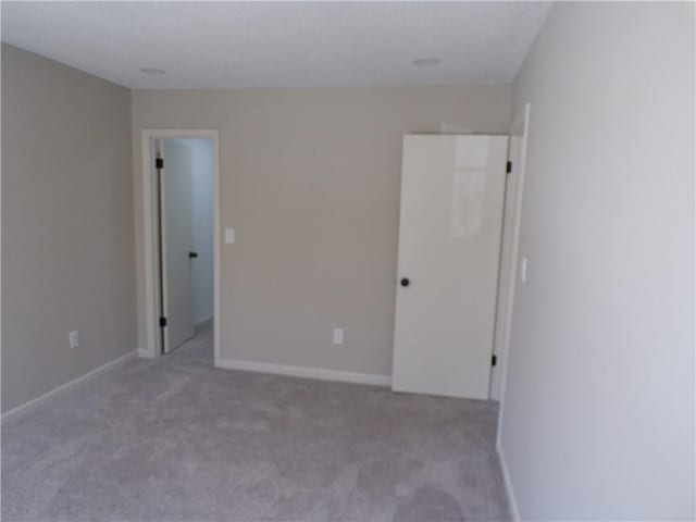 unfurnished bedroom featuring carpet floors and baseboards