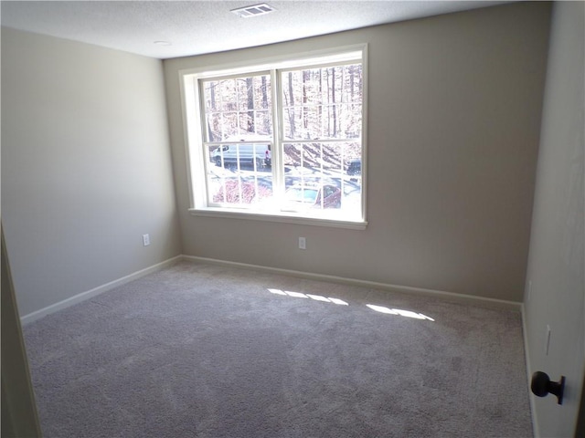 unfurnished room featuring baseboards, visible vents, a textured ceiling, and carpet flooring