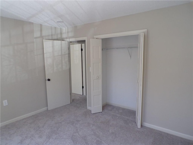 unfurnished bedroom featuring carpet floors, a closet, and baseboards