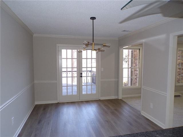 unfurnished dining area with a textured ceiling, ornamental molding, wood finished floors, and visible vents