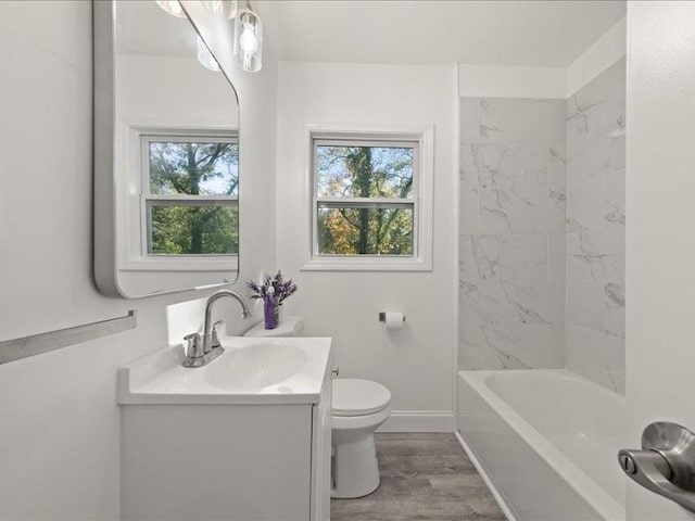 full bathroom with vanity, hardwood / wood-style flooring, toilet, and tiled shower / bath