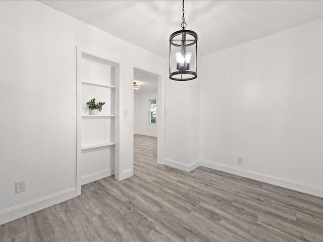 unfurnished dining area featuring hardwood / wood-style floors and an inviting chandelier