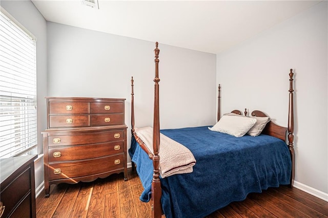 bedroom with dark wood-type flooring, baseboards, and visible vents