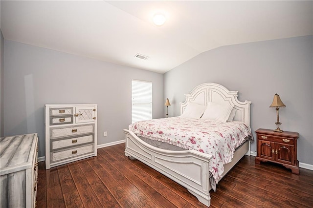 bedroom with visible vents, baseboards, dark wood-type flooring, and vaulted ceiling