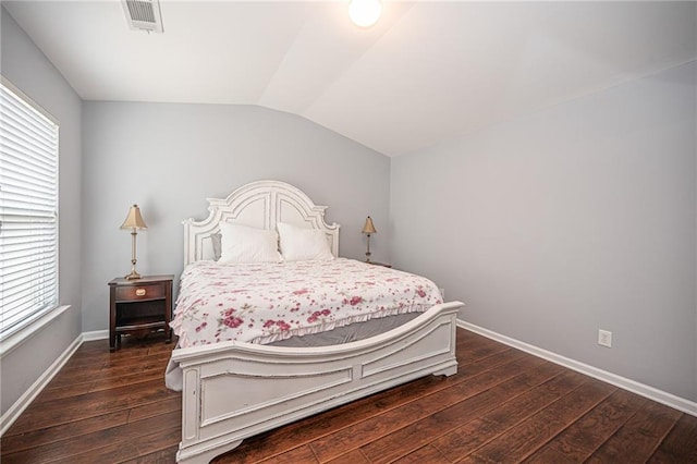 bedroom with visible vents, lofted ceiling, dark wood-type flooring, and baseboards