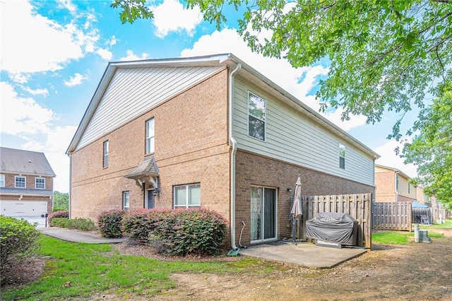 back of property featuring brick siding, a patio, and fence