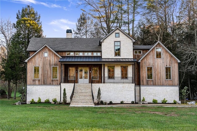 modern farmhouse with a front lawn and french doors