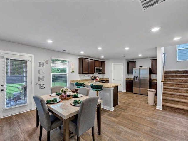 dining space featuring light wood-type flooring, stairs, and recessed lighting