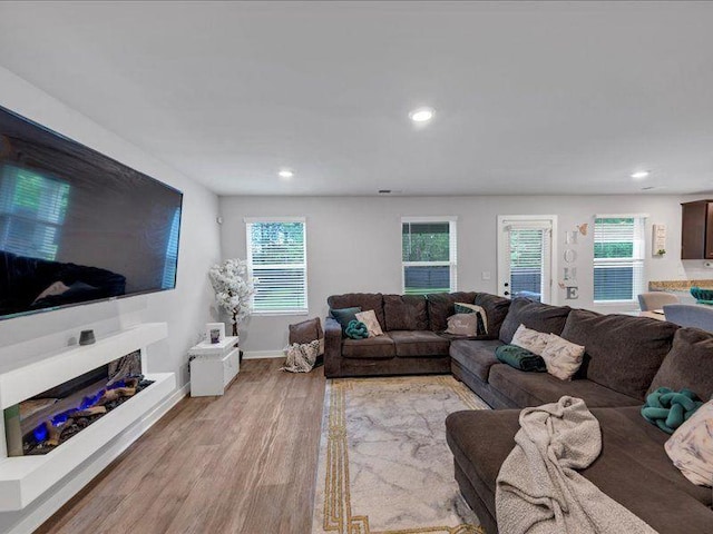 living room featuring light wood-style floors, recessed lighting, healthy amount of natural light, and baseboards