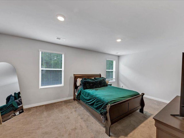 bedroom featuring light colored carpet, multiple windows, baseboards, and recessed lighting