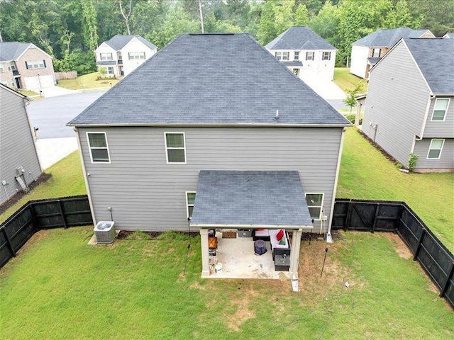 back of house featuring a patio, central AC, a shingled roof, and a residential view