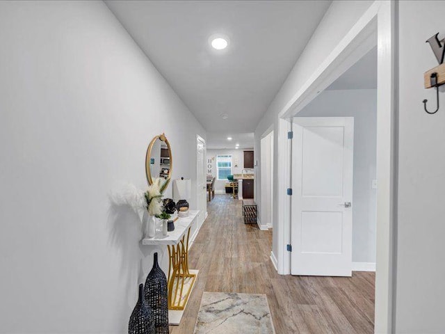 hall with light wood finished floors, recessed lighting, and baseboards