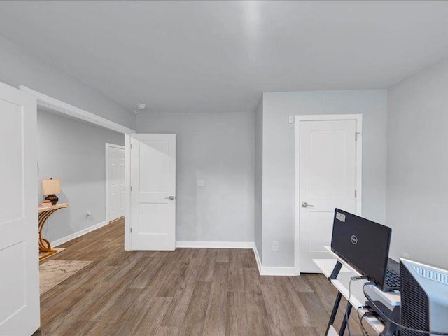 unfurnished office with wood finished floors and baseboards