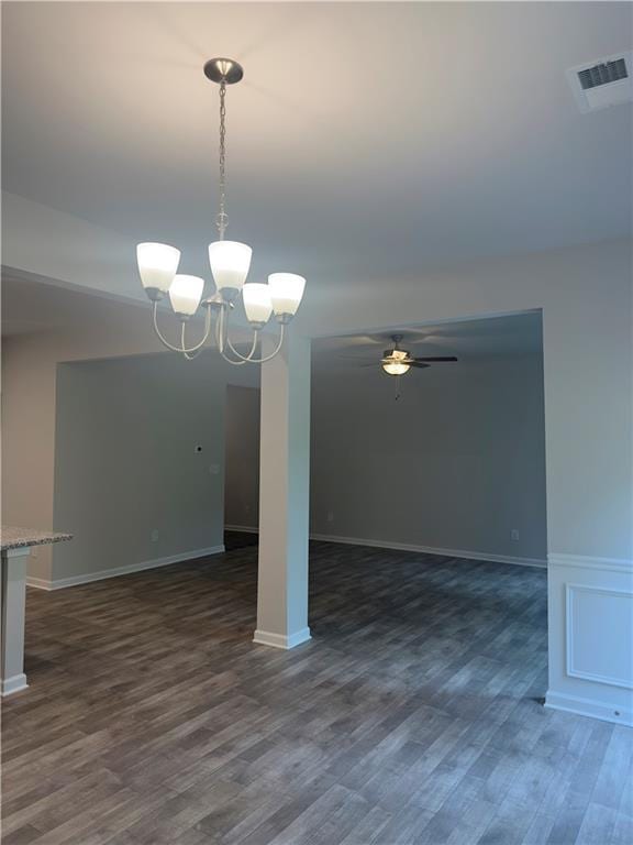 unfurnished dining area with dark wood finished floors, visible vents, baseboards, and ceiling fan with notable chandelier