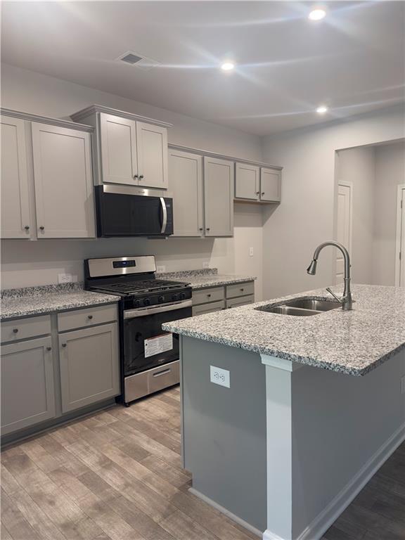 kitchen featuring gray cabinetry, appliances with stainless steel finishes, and a sink