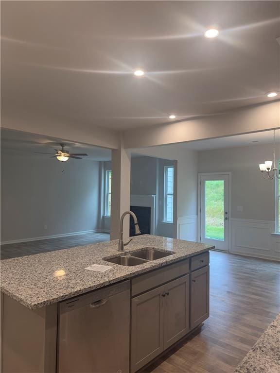 kitchen with open floor plan, a sink, a kitchen island with sink, and stainless steel dishwasher